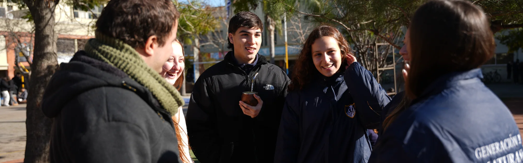 Estudiantes de Bachillerato conversando en el patio del colegio.