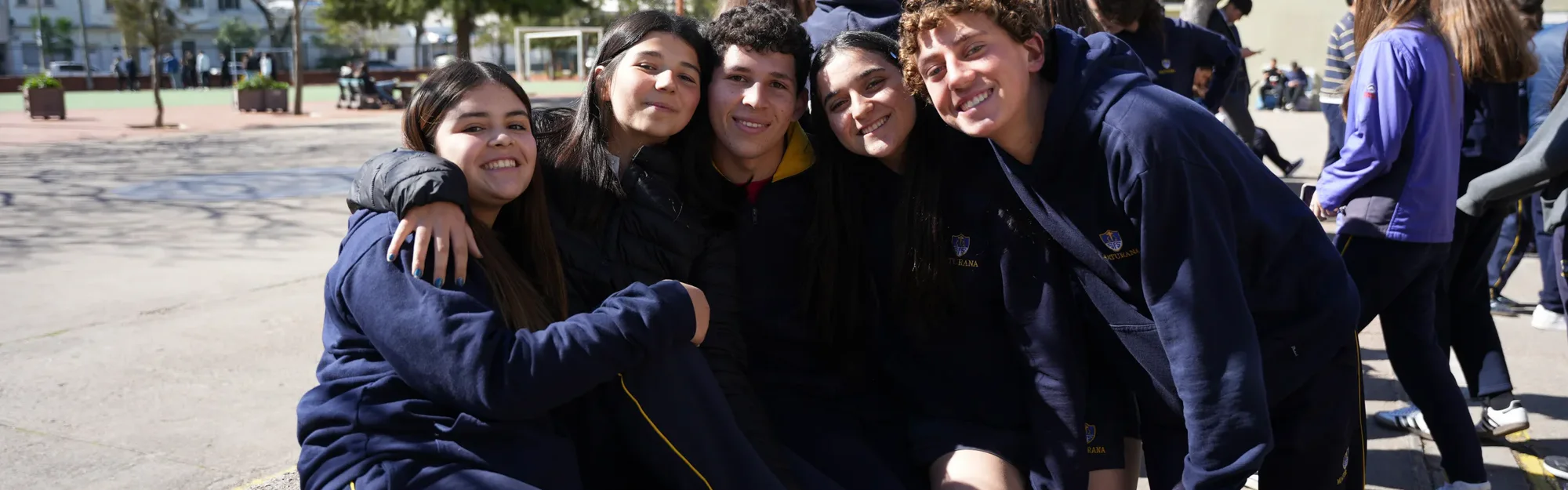 Grupo de estudiantes de Ciclo Básico compartiendo en el patio del colegio.